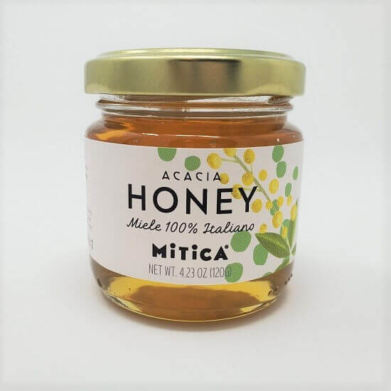 Jar of Acacia honey with a gold lid on a white background
