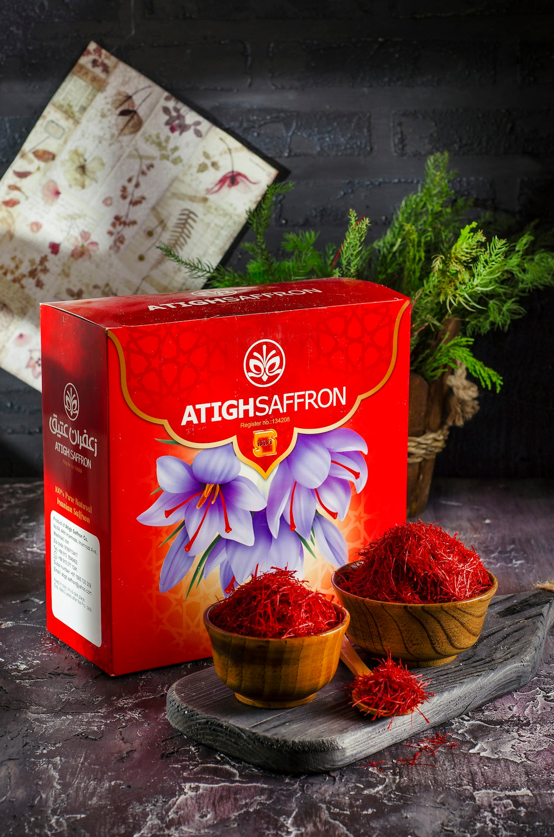 a box of saffron powder next to a bowl of saffron