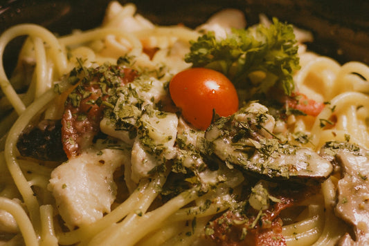A close up of a plate of pasta with broccoli