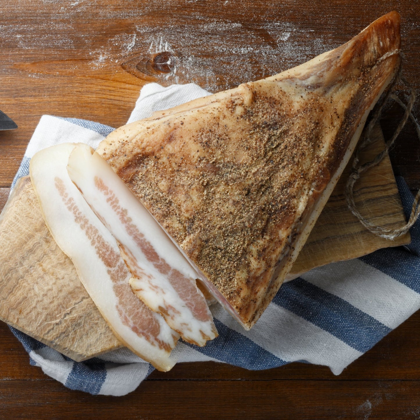 Smoked meat on a wooden cutting board with a striped cloth underneath