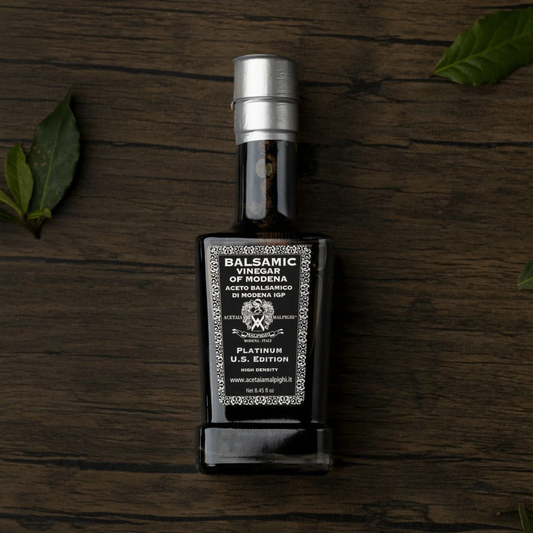 Balsamic vinegar bottle on a wooden surface with leaves