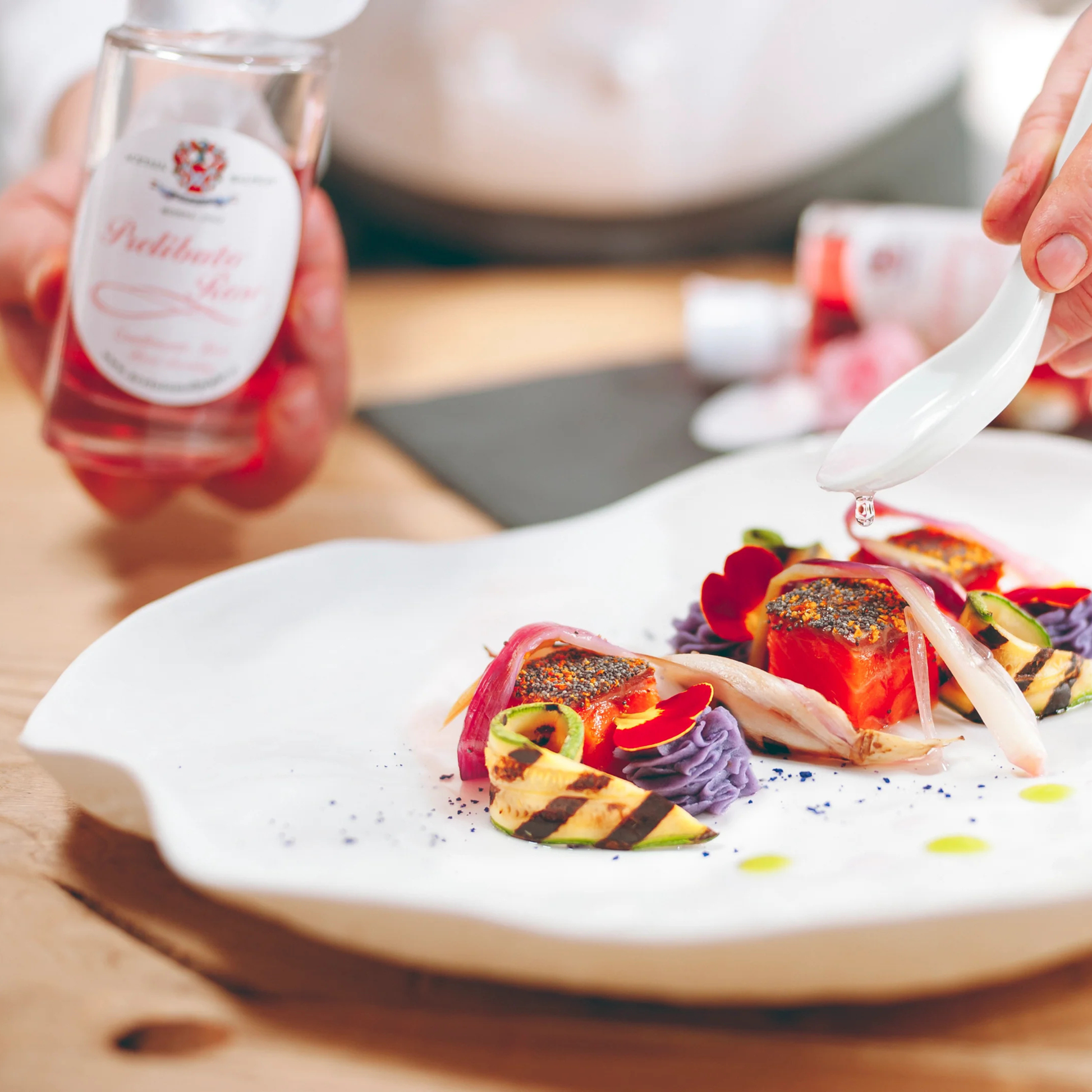 Culinary dish with a bottle of rosé wine on a wooden table
