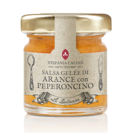 Jar of orange marmalade with a gold lid on a white background