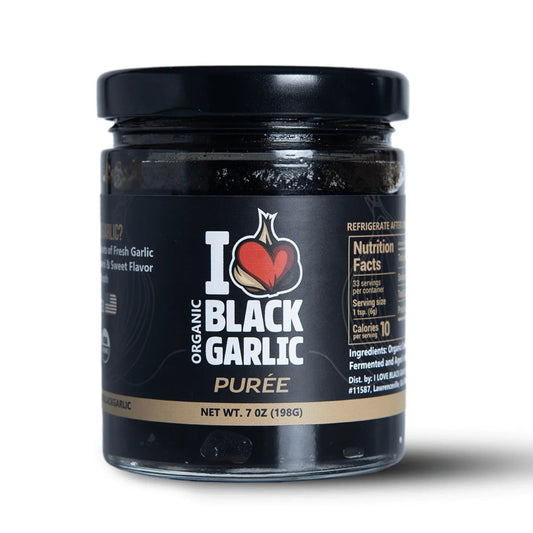 Jar of organic black garlic puree on a white background